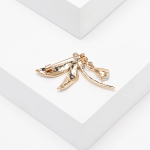 Detailed back view of gold dragonfly brooch with pin clasp and clear gemstone pendant