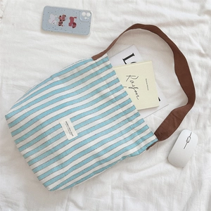 Detailed top view of striped canvas tote bag showing interior storage capacity with books