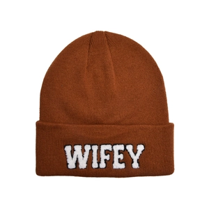 Detail of brown knitted beanie featuring white WIFEY embroidered patch on cuff