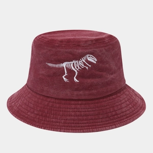 Detailed embroidery of a white dinosaur skeleton on a washed burgundy cotton bucket hat