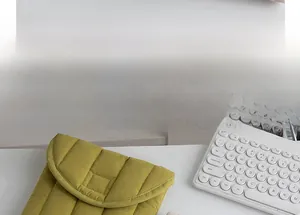 Close-up of olive green quilted laptop sleeve showing padded texture and flap closure