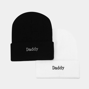Detail of Daddy embroidery on black and white knitted beanies in soft acrylic fabric