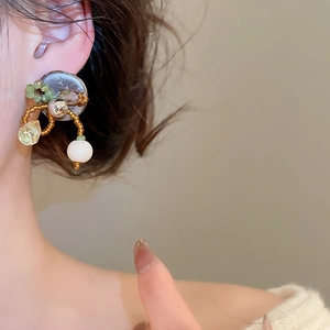 Vue détaillée de la boucle d'oreille ethnique avec perles vertes et nacre sur base grise