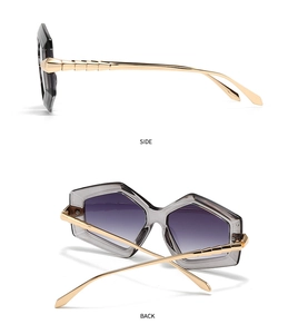 Detail view of square sunglasses featuring purple gradient lenses and gold metal temples