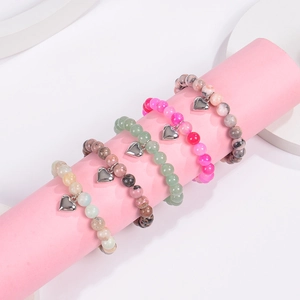 Natural stone beaded bracelets with heart pendants displayed on jewelry stands