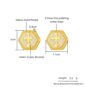 Macro shot of gold-plated hexagonal stud earring with cross and cubic zirconia details
