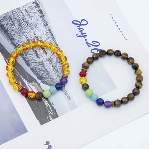 Close-up of natural tiger eye stone beads and colorful chakra energy yoga bracelets