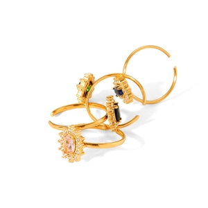 Set of four gold-plated sunburst open rings with colorful zirconia stones on white background