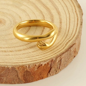 Macro shot of 18k gold plated stainless steel ring featuring unique hands hug design