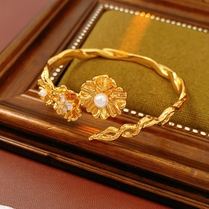 Detail of vintage flower bangle with pearls and zircons on green velvet background