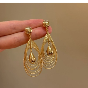 Detail of 18k gold plated multi-layer teardrop earrings with textured nested rings