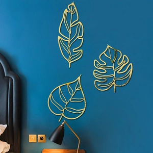 Lot de 3 décorations murales feuilles en métal doré dans une chambre chaleureuse