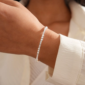 Detail view of silver beaded geometric crisscross open bracelet with micro-pave diamond accents