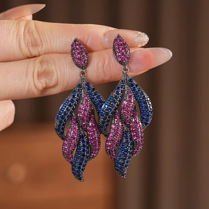 Macro shot of vintage style water-drop leaf earrings with blue and magenta zircons