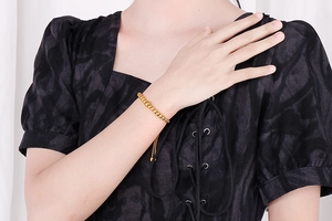 Detailed view of adjustable gold beaded bracelet worn on wrist with sleek draw-string closure