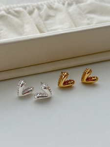 Detail of 925 silver textured heart stud earrings in gold and silver finishes on tray