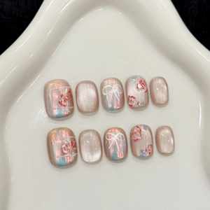 Short square press-on nails with aurora pink cat eye effect and 3D floral bow designs