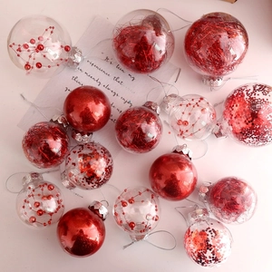 Detail view of red and clear Christmas balls with sequins and ribbons for tree decoration