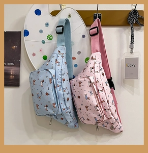 Detail of pink and blue cartoon dog crossbody bags with adjustable straps and dual zippers