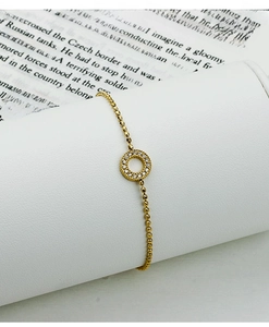 Detail view of 18K gold-plated beaded bracelet with a sparkling zircon encrusted charm