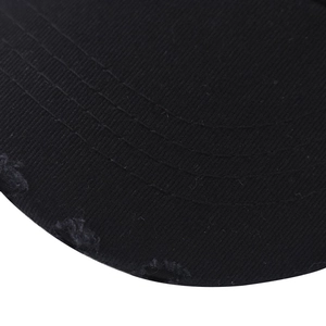 Detail of black cotton baseball cap brim showing vintage distressed frayed edges and stitching