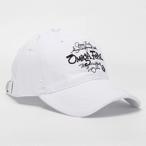 Gros plan sur la broderie OMEGA FIRE d'une casquette blanche au style vintage usé