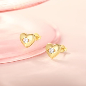 Detailed macro view of heart-shaped gold studs with square zircon and openwork design