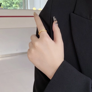 Close-up of minimalist 925 silver gold-plated entwined line ring on finger