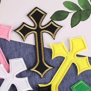 Colorful cross embroidery patches stacked on denim fabric for clothing decoration