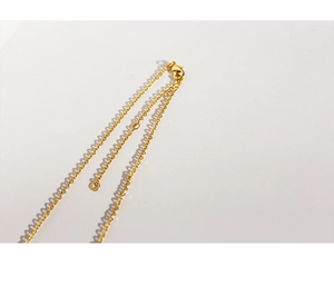 Macro detail of the gold-plated necklace lobster clasp and adjustable extension chain
