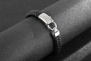 Gros plan du bracelet pour homme en cuir tressé noir avec fermoir en acier poli brillant