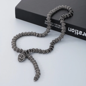 Vintage punk silver snake pendant necklace in coiled design on black background