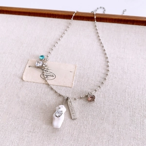 Detailed view of silver bear necklace with colorful zircons and engraved metal tag