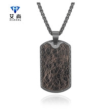 Detail of black rectangular pendant with brown woven inlay and robust twist chain