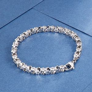 Macro shot of silver stainless steel floral link bracelet with secure lobster clasp detail