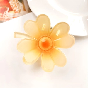 Detail of yellow gradient frangipani hair claw clip made of translucent resin material