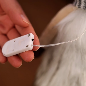 Detail of white plastic battery compartment and black toggle switch for light-up plush toys