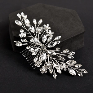 Exquisite bridal hair comb with shimmering crystals and pearls on a sleek black pedestal