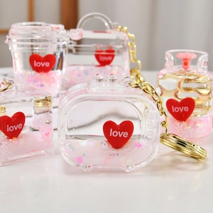 Macro shot of liquid sand keychains with pink glitter and red love heart charms