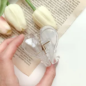 Detail showing high-quality transparent acrylic heart hair claw with golden spring mechanism
