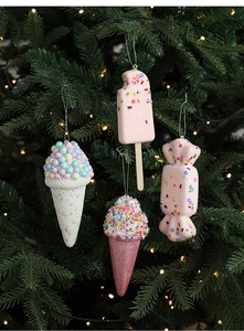 Close-up of pink ice cream and popsicle ornaments hanging on a green Christmas tree