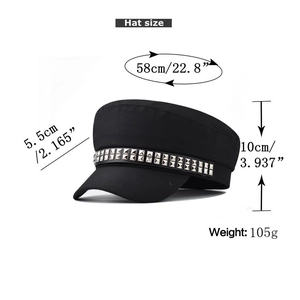 Detail of black baker boy hat featuring silver rivet studs and decorative strap