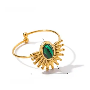 Detailed view of vintage gold ring with oval green malachite and sunburst metal rays