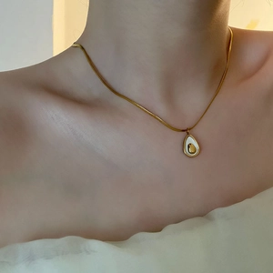 Elegant gold snake chain necklace featuring a minimalist avocado shell pendant on a model