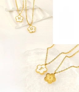 Macro detail of 18K gold stainless steel clover pendant showing the front and back texture