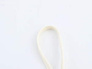 Macro shot of beige 3D floral strap detail and stitching on the crop camisole top