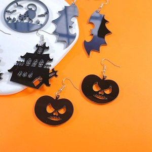 Halloween acrylic earrings featuring black pumpkin, bat, and ghost house on orange background
