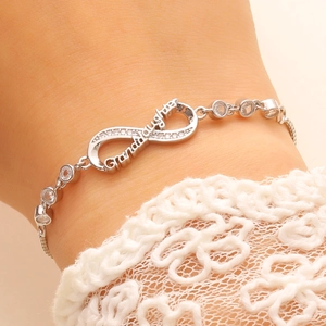 Detailed view of infinity bracelet with micro-pave stones and Granddaughter engraving