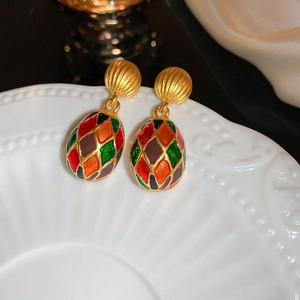 Vintage court style gold earrings with colorful enamel diamond pattern on white plate