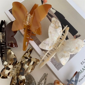 Elegant acetate butterfly hair claw clips in tortoise shell and cream pearl finishes